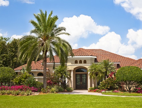 two story home with palm trees in front yard
