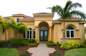 beige florida home with palm tree in front